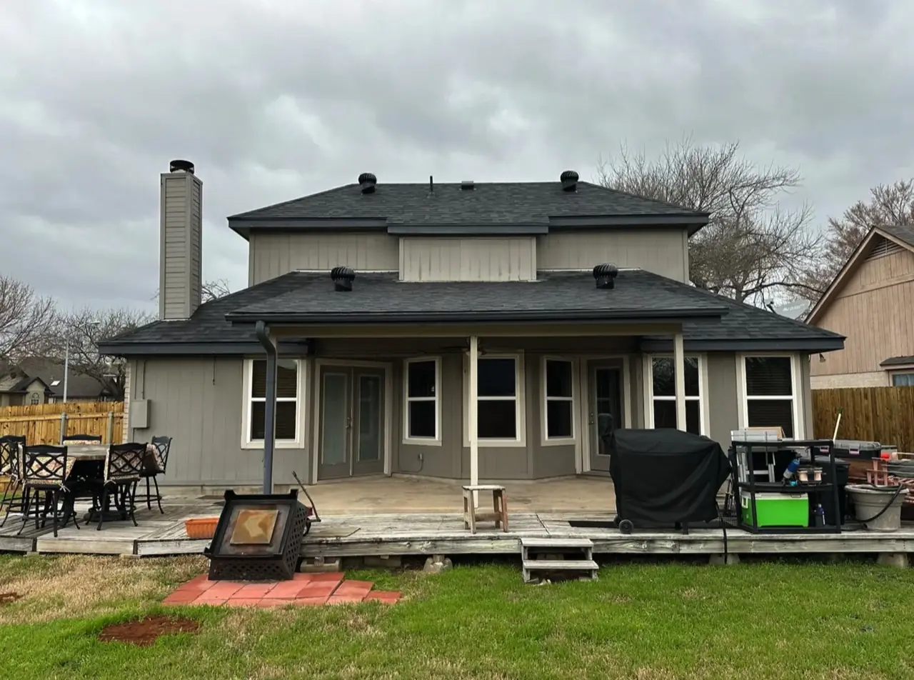 Faded gray two-story exterior and covered patio before repainting