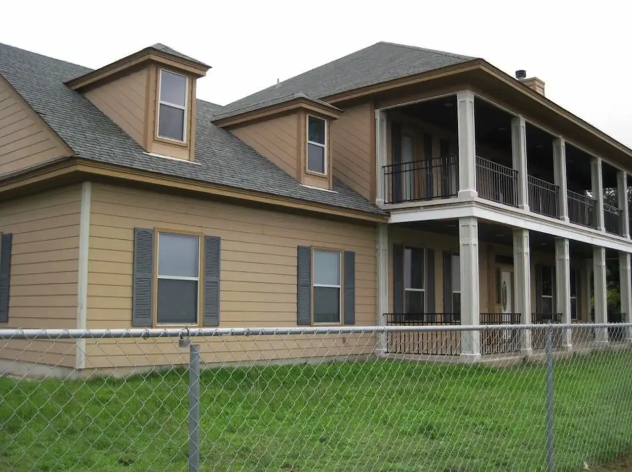Tan double-porch home exterior before repainting