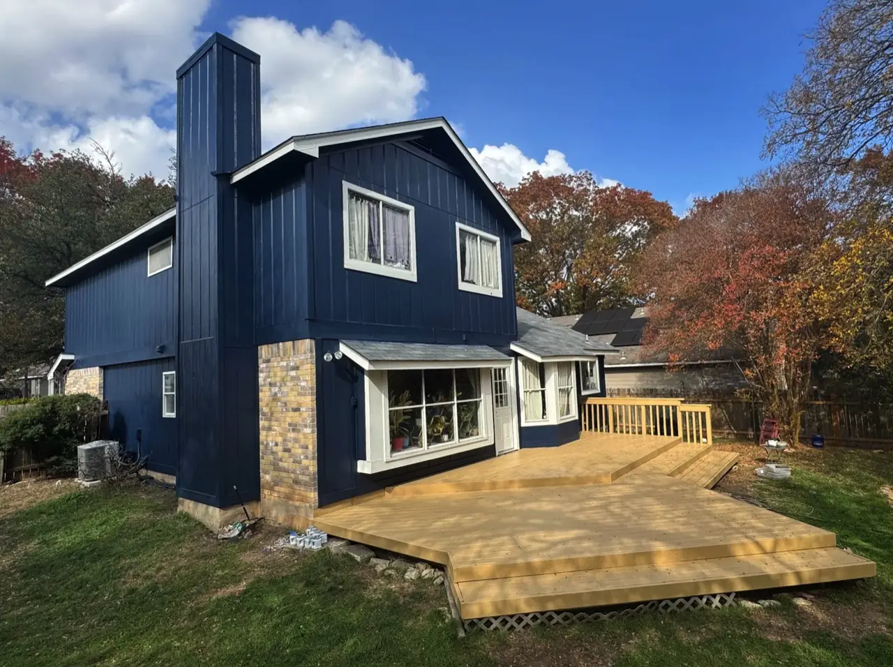 The same home after Tex Painting repainted it navy blue and refinished the deck
