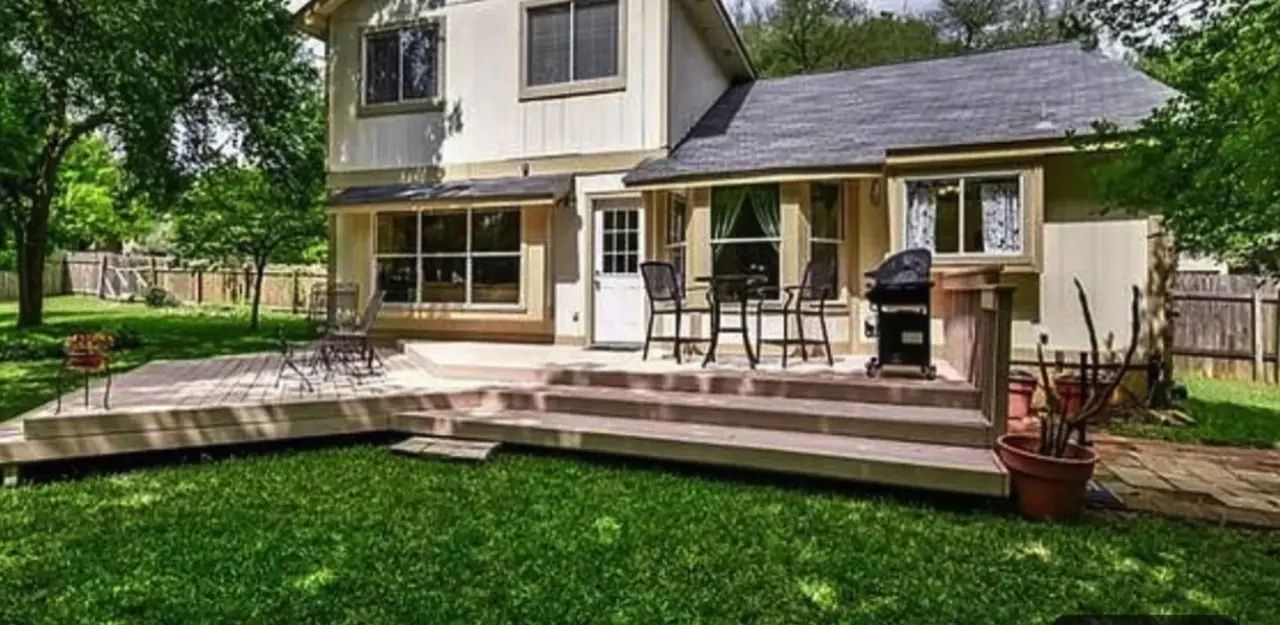 Cream-colored home exterior and worn deck before repainting