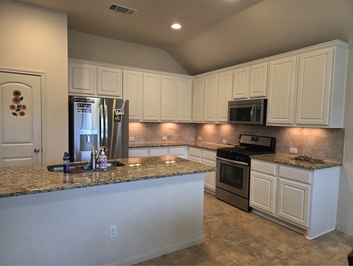Kitchen with repainted white cabinets and a clean ceiling finish